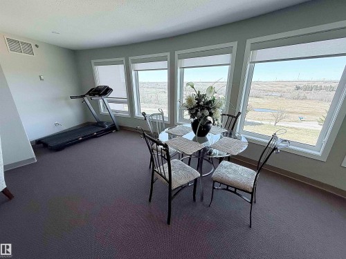 Wall of windows featuring roller shades and a natural landscape - 410 9926 100 Avenue, Fort Saskatchewan, AB - Indoor
