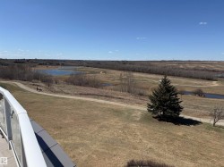 Expansive natural landscape featuring multiple ponds and paved walking paths - 