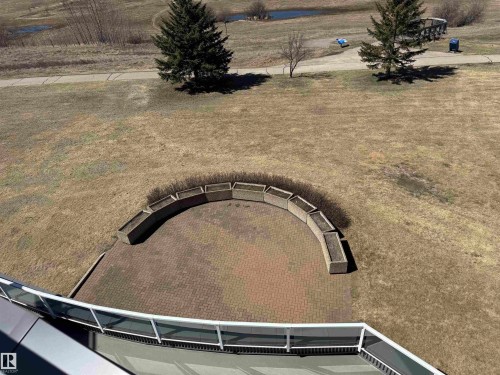 Paved patio with curved stone planters and expansive outdoor space - 410 9926 100 Avenue, Fort Saskatchewan, AB -  Photo Showing Other Room