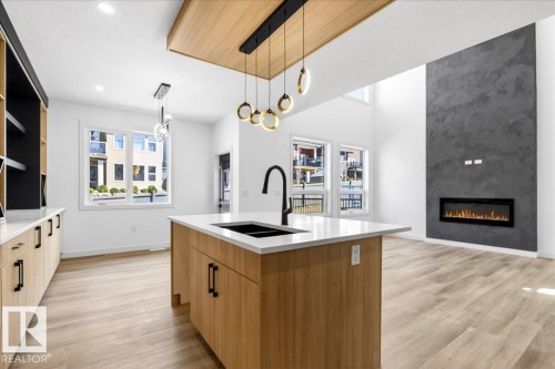 1150 Gyrfalcon Crescent, Edmonton, AB - Indoor Photo Showing Kitchen With Fireplace With Double Sink
