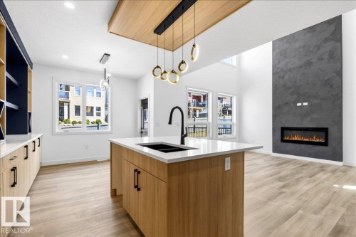 1150 Gyrfalcon Crescent, Edmonton, AB - Indoor Photo Showing Kitchen With Fireplace With Double Sink