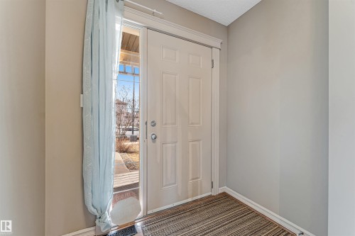 Entryway featuring a paneled door, sidelight window, and textured area rug - 1431 Hodgson Way, Edmonton, AB - Indoor Photo Showing Other Room