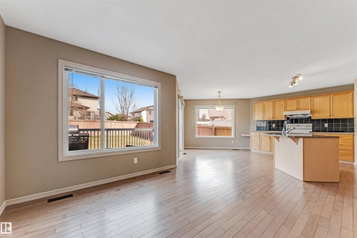 Open-concept living space featuring light wood-finish flooring throughout - 1431 Hodgson Way, Edmonton, AB - Indoor Photo Showing Kitchen
