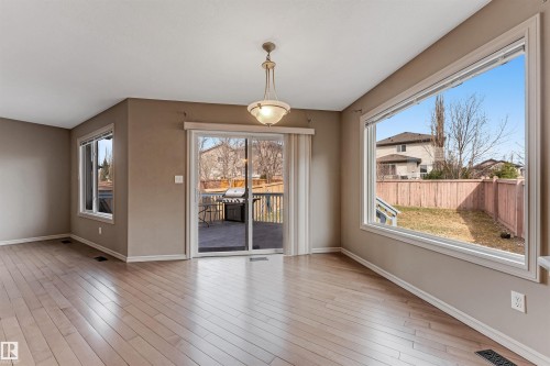 Spacious room featuring light wood-finish flooring, neutral wall tones, and white trim - 1431 Hodgson Way, Edmonton, AB - Indoor Photo Showing Other Room