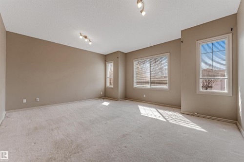 Spacious room featuring neutral carpeting and wall tones - 1431 Hodgson Way, Edmonton, AB - Indoor Photo Showing Other Room