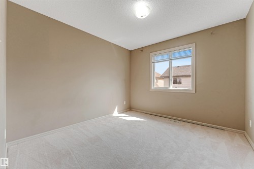 Neutral tone walls with white trim and light carpet flooring - 1431 Hodgson Way, Edmonton, AB - Indoor Photo Showing Other Room