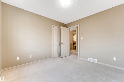 Neutral-toned room featuring light gray carpeting, a single ceiling light fixture, and white trim - 1431 Hodgson Way, Edmonton, AB - Indoor Photo Showing Other Room