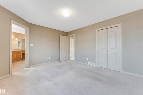 Spacious room featuring neutral wall paint, light-colored carpeting, and a ceiling-mounted light fixture - 1431 Hodgson Way, Edmonton, AB - Indoor Photo Showing Other Room