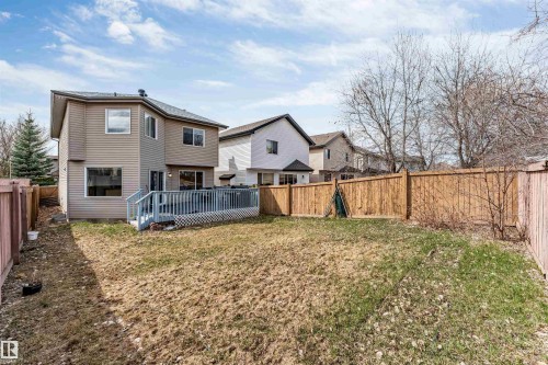 Expansive backyard featuring a large wooden deck, full privacy fencing, and mature trees - 1431 Hodgson Way, Edmonton, AB - Outdoor