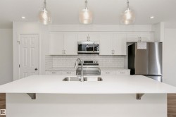 Spacious kitchen island featuring a dual-basin undermount sink and modern faucet - 