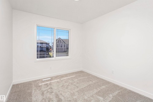 Bright room featuring a multi-pane window, neutral carpet flooring, white walls, and recessed lighting - 9552 Carson Bend Bend, Edmonton, AB - Indoor Photo Showing Other Room