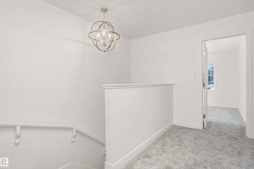 Bright landing area featuring a contemporary spherical chandelier and light grey carpeting - 9552 Carson Bend Bend, Edmonton, AB - Indoor Photo Showing Other Room