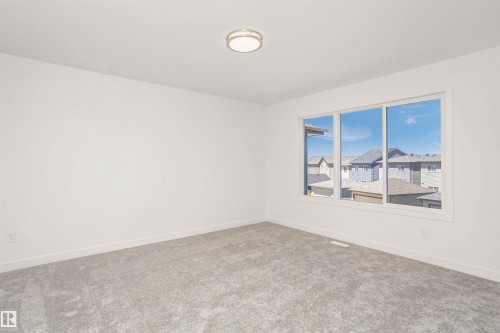 Bright room with neutral gray carpeting and white walls - 9552 Carson Bend Bend, Edmonton, AB - Indoor Photo Showing Other Room