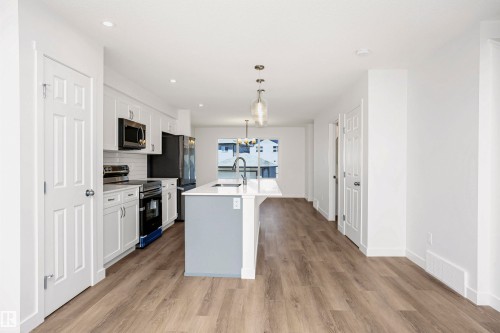 Contemporary kitchen with white cabinetry, a light gray island base, and a white countertop - 9552 Carson Bend Bend, Edmonton, AB - Indoor Photo Showing Kitchen