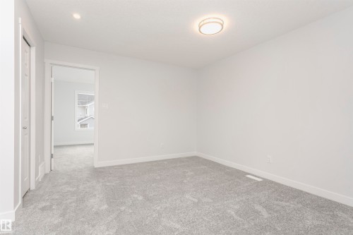 Spacious room featuring light gray carpeting, white painted walls, white trim, a flush mount ceiling light, and a recessed ceiling light - 9564 Carson Bend Bend, Edmonton, AB - Indoor Photo Showing Other Room