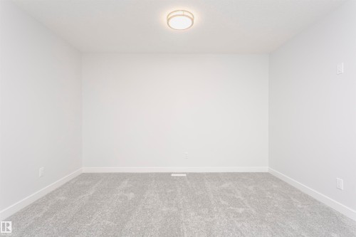 Neutral white walls featuring a contemporary flush-mount ceiling light, light gray carpeting, and white baseboards - 9564 Carson Bend Bend, Edmonton, AB - Indoor Photo Showing Other Room