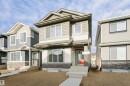 Contemporary two-story residence featuring multi-toned siding, stone veneer accents, and a prominent red front door - 9564 Carson Bend Bend, Edmonton, AB  - Outdoor With Facade 