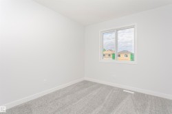 Bright room featuring a large window, plush gray carpet, and crisp white walls and trim - 