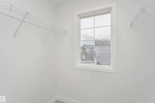 Walk-in closet with grid wire shelving and a window featuring muntins and white trim - 9564 Carson Bend Bend, Edmonton, AB - Indoor With Storage