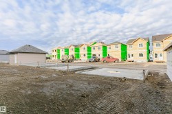 New construction foundations in place, with multiple framed homes in various stages of completion - 