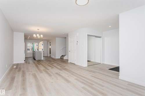 Open-concept living area featuring light wood-finish flooring, recessed lighting, and a modern chandelier - 9564 Carson Bend Bend, Edmonton, AB - Indoor Photo Showing Other Room
