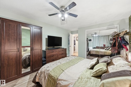 Bedroom featuring wood-finish flooring, a ceiling fan with integrated lighting, and light-toned wall paint - 105 7204 81 Avenue, Edmonton, AB - Indoor Photo Showing Bedroom