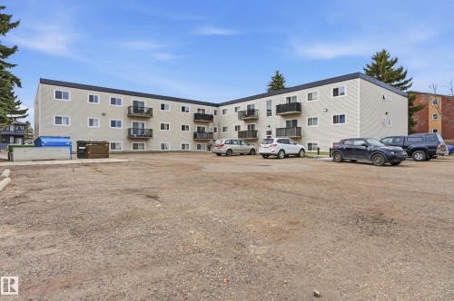 Three-story building with light-colored siding and a dark roof - 105 7204 81 Avenue, Edmonton, AB - Outdoor