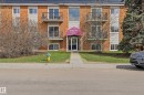 Brick and siding multi-story building featuring individual balconies with black railings, a central entrance with a purple awning, and a sidewalk entrance - 105 7204 81 Avenue, Edmonton, AB  - Outdoor With Facade 