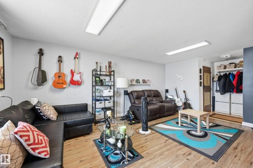 Open concept living area featuring light wood-finish flooring, recessed lighting, and a built-in storage closet - 105 7204 81 Avenue, Edmonton, AB - Indoor Photo Showing Living Room