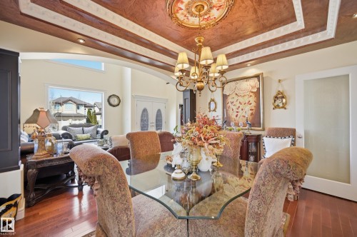 Dining area featuring a prominent chandelier, an ornate ceiling medallion, and decorative ceiling paneling - 3105 65 Street, Beaumont, AB - Indoor Photo Showing Dining Room