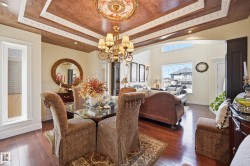 Formal dining area featuring a tray ceiling with decorative molding and central chandelier - 