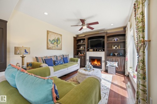 Open-concept living space featuring wood-finish flooring, recessed lighting, and a ceiling fan - 3105 65 Street, Beaumont, AB - Indoor Photo Showing Living Room With Fireplace