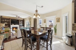 Dining area featuring a bronze chandelier, light tile flooring, and multiple windows with decorative trim - 