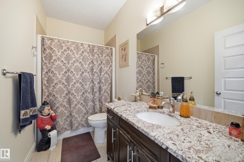 Bathroom with a single vanity featuring a light-colored countertop, an undermount sink, and a chrome faucet - 3105 65 Street, Beaumont, AB - Indoor Photo Showing Bathroom