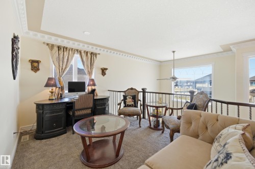 Open loft area featuring a window with exterior visibility, a ceiling fan, and decorative crown molding - 3105 65 Street, Beaumont, AB - Indoor Photo Showing Other Room