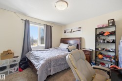 Carpeted bedroom with a single window, a flush-mount ceiling light fixture, and light-colored walls - 