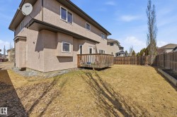 Spacious backyard featuring a wooden deck, privacy fencing, and a raised garden bed - 