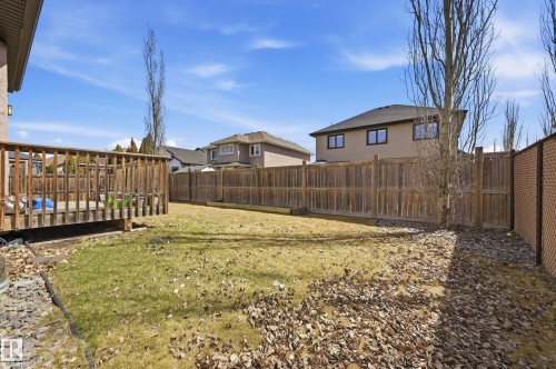 Spacious backyard featuring a wood deck, wood privacy fencing, and a brick-patterned fence - 3105 65 Street, Beaumont, AB - Outdoor