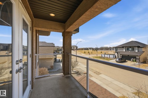 Covered balcony with glass railings and light-colored French doors - 3105 65 Street, Beaumont, AB - Outdoor With Exterior