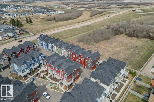 Aerial perspective showcasing a community of multi-story townhomes with varying exterior colors - 21 979 Crystallina Nera Way, Edmonton, AB -  With View