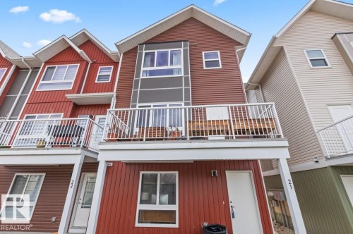 Two-story townhouse exterior with red siding and white trim - 21 979 Crystallina Nera Way, Edmonton, AB - Outdoor With Balcony