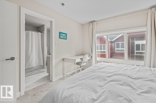 Bedroom featuring light-toned carpeting and a window with white drapes - 21 979 Crystallina Nera Way, Edmonton, AB - Indoor Photo Showing Bedroom