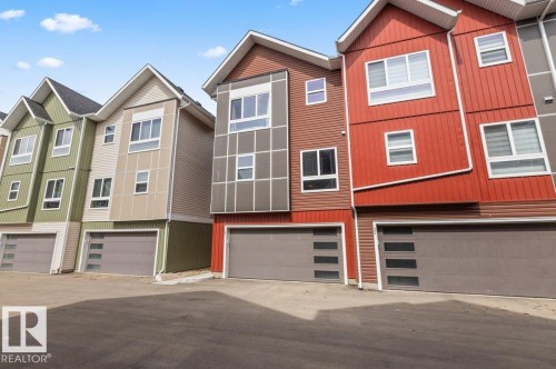 Modern row of properties featuring multiple siding materials, large windows, and contemporary garage doors - 21 979 Crystallina Nera Way, Edmonton, AB - Outdoor With Facade