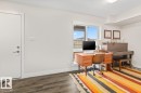 Spacious room with wood-finish flooring, white baseboards, and a single window offering exterior views - 21 979 Crystallina Nera Way, Edmonton, AB  - Indoor Photo Showing Office 