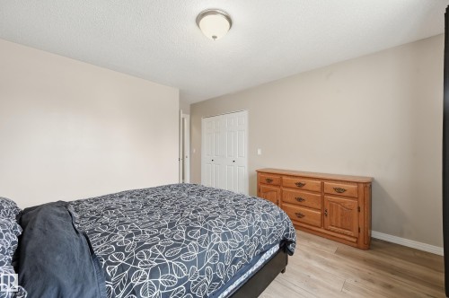 Neutral wall tones complement the wood-finish flooring - 1729 65 Street, Edmonton, AB - Indoor Photo Showing Bedroom