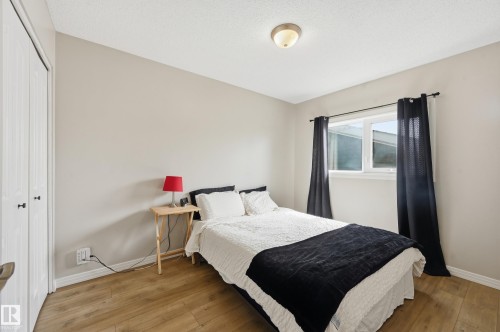 Bedroom featuring wood-finish flooring, a double-pane window, and a ceiling-mounted light fixture - 1729 65 Street, Edmonton, AB - Indoor Photo Showing Bedroom