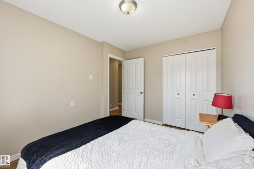 Bedroom featuring a neutral wall color, white bi-fold closet doors, a white paneled door, and a flush-mount ceiling light fixture - 1729 65 Street, Edmonton, AB - Indoor Photo Showing Bedroom