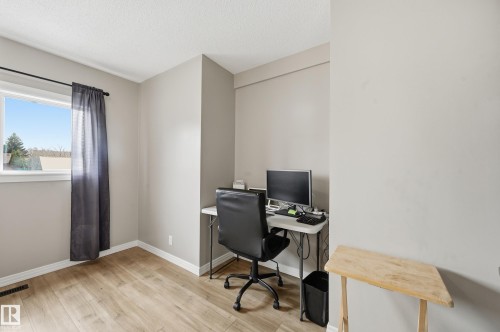 Interior room featuring light-toned walls, wood-finish flooring, and a single window with white trim - 1729 65 Street, Edmonton, AB - Indoor Photo Showing Office