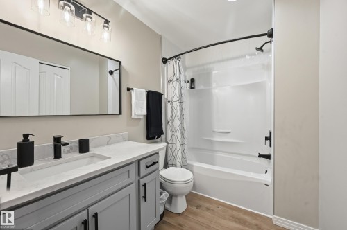 Bathroom featuring a single vanity with light grey cabinetry, white countertop, and integrated sink - 1729 65 Street, Edmonton, AB - Indoor Photo Showing Bathroom