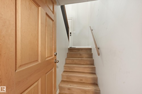 Entryway featuring a paneled wood door and wood-finish stairs with a coordinating wood handrail - 1729 65 Street, Edmonton, AB - Indoor Photo Showing Other Room
